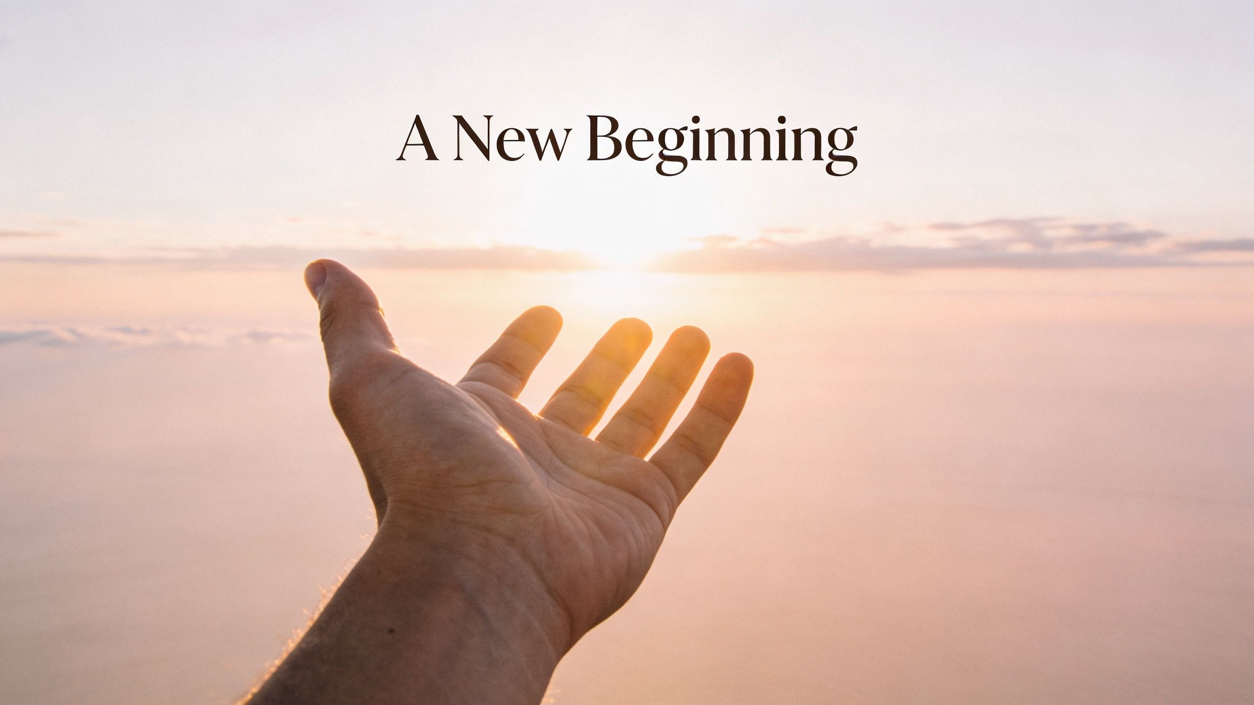 A hand reaching towards a bright sunrise over the clouds with the text A New Beginning