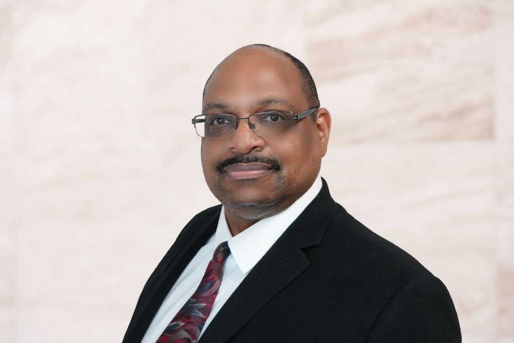 Byron Shaw, attorney specializing in family and criminal law, professional headshot with formal attire and glasses, neutral background.