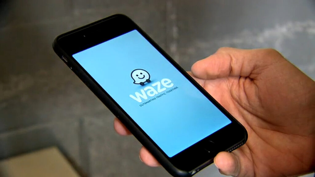 Person holding smartphone displaying the Waze app interface, relevant to DUI alerts and driving safety.