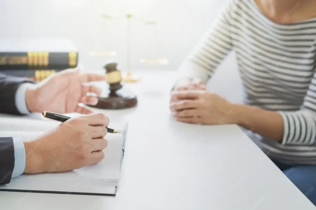 Attorney discussing legal strategies with a client, gavel and law books in background, representing criminal defense services in Atascocita.