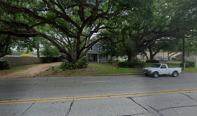 Richmond office location of Bryan Fagan Law Office, featuring a large house surrounded by trees and a parked white pickup truck on the street.