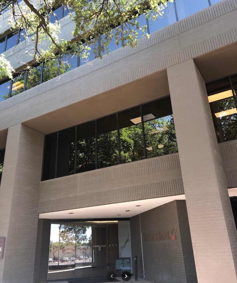 San Antonio office building exterior featuring large glass windows, entrance with "Vantage Bank" signage, surrounded by trees, located in San Antonio, Texas.