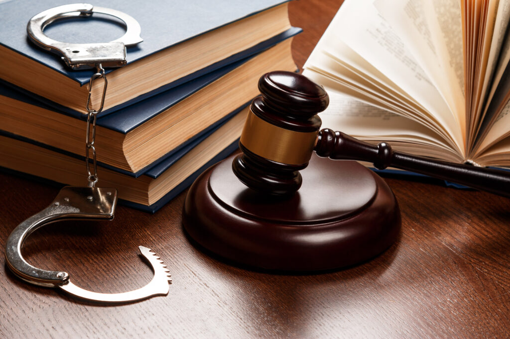 Gavel, handcuffs, and law books on wooden table, symbolizing Texas robbery legislation and criminal law.